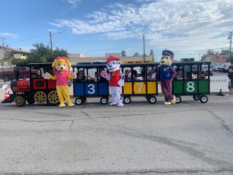 mascots stand near train