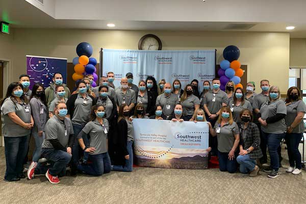 Personal del Temecula Valley Hospital sosteniendo una pancarta y celebrando su afiliación con Southwest Healthcare