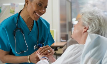 A nurse holding a patient's hand