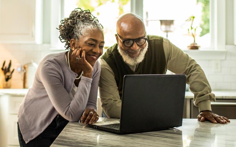 A man and woman taking a health risk assessment on a laptop