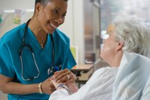 A nurse holding a patient's hand