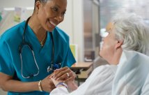 A nurse holding a patient's hand